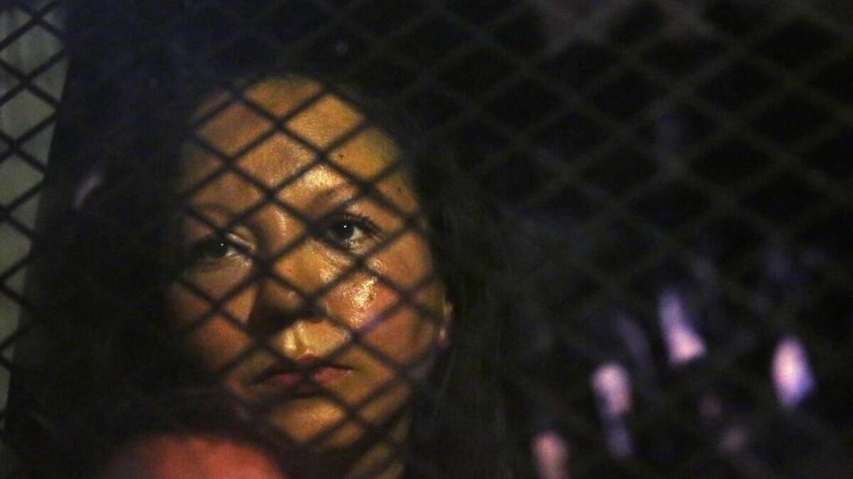 Guadalupe Garcia de Rayos is locked in a van that is stopped in the street by protesters outside the Immigration and Customs Enforcement facility in Phoenix. Advocacy groups said that Immigration and Customs Enforcement officers are rounding up people in large numbers around the country as part of stepped-up enforcement under President Donald Trump.