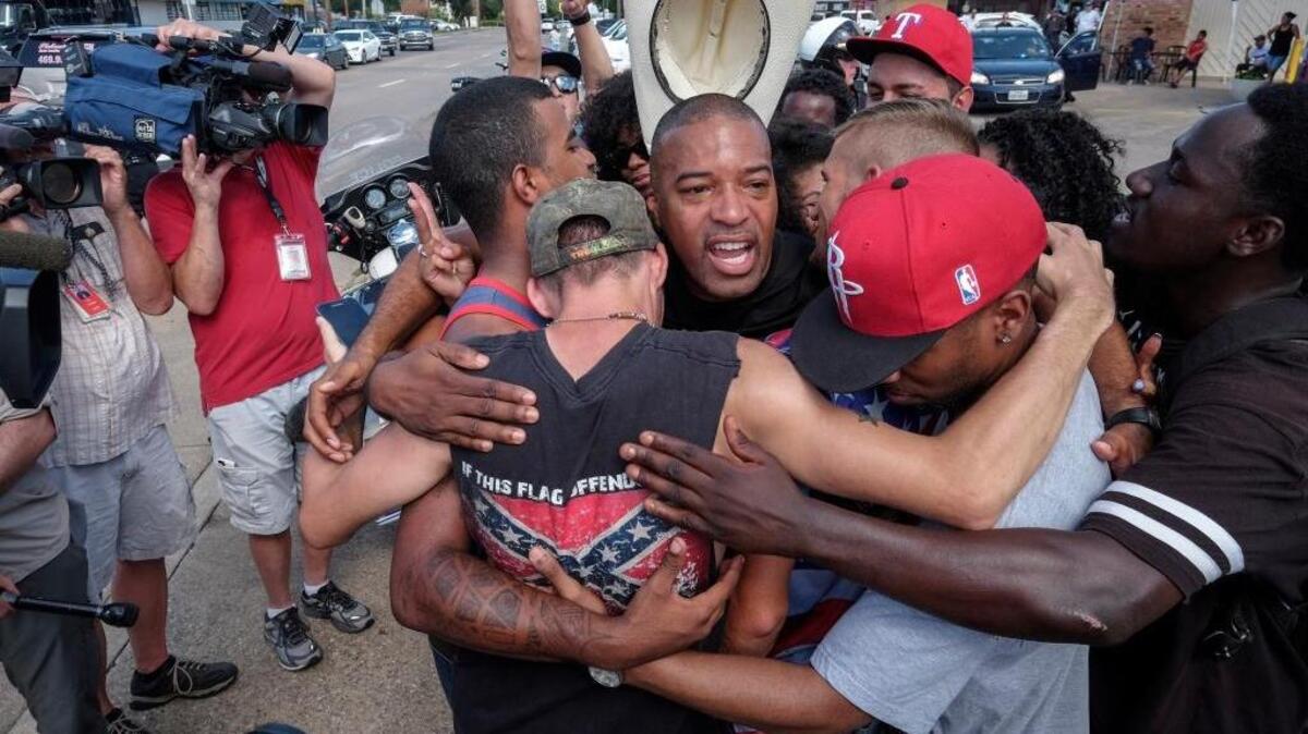 Ty Hardaway, 44, of Dallas is in the center of a group hug after some marchers from Black Lives Matter had a meeting with a counter-protest group supporting Blue Lives Matter. The two groups stood on separate sides of a busy intersection and ultimately came to an understanding.