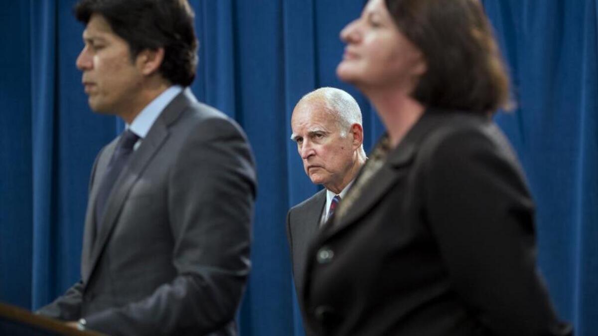 
Gov. Jerry Brown listens as Senate President pro Tem Kevin de León and Assembly Speaker Toni Atkins announce they will abandon efforts this year to require a 50 percent reduction in petroleum use in motor vehicles by 2030.
