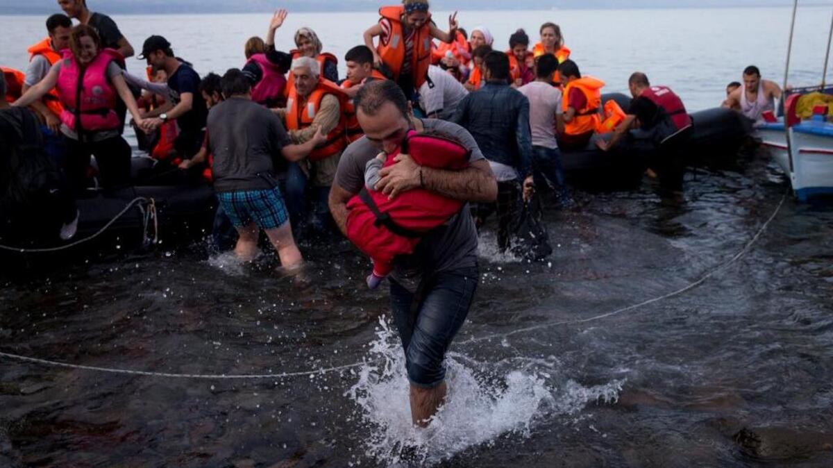 
Syrian refugees arrive on a dinghy after crossing from Turkey to the Greek island of Lesbos on Wednesday. The head of the European Union said 22 of its member states should be forced to accept another 120,000 people in need of international protection.
