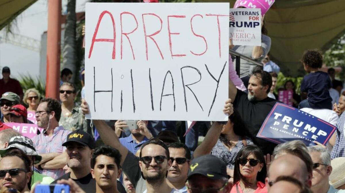 A supporter of Republican presidential candidate Donald Trump holds up a sign referring to Democratic presidential candidate Hillary Clinton during a Trump campaign rally in Miami on Wednesday.