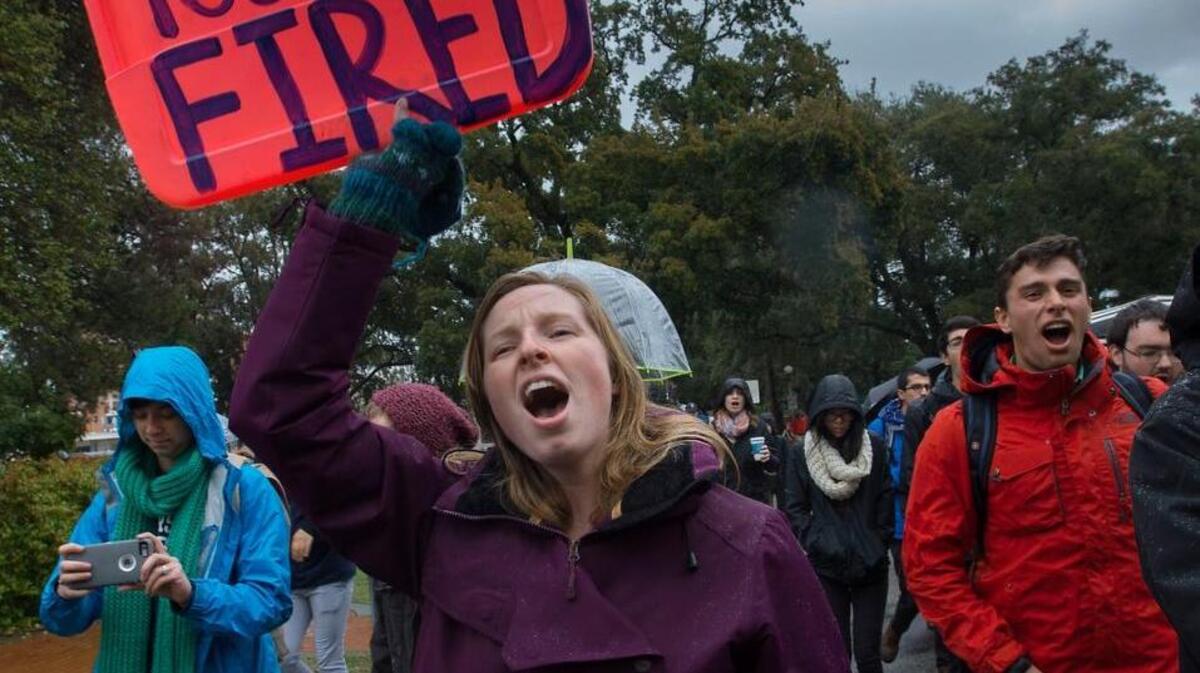 A student protester carries a sign and chants slogans on the UC Davis campus demanding Chancellor Linda Katehi’s resignation.
