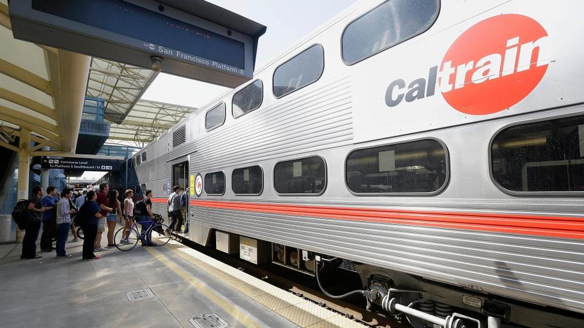 Commuters board a Caltrain train at the station in Millbrae. The Federal Transit Administration is delaying a decision on whether to approve a $650 million federal grant for electrification of a San Francisco Bay Area train system that would also help California’s high-speed rail project.