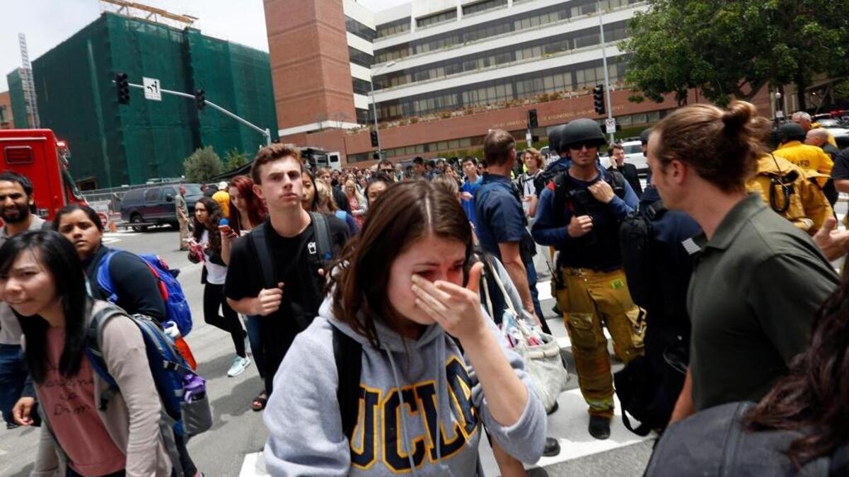 A tearful UCLA student joins hundreds of other students as they leave the campus after the lockdown was called off Wednesday.