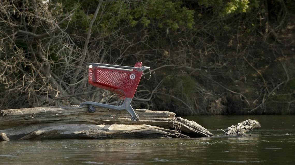 A shopping cart sits in the middle of the American River between Watt Avenue and Discovery Park. The water is polluted with E. coli from garbage and human waste.