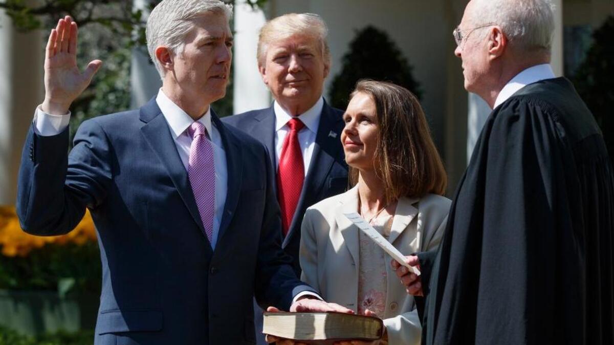 President Donald Trump watches as Supreme Court Justice Anthony Kennedy, right, administers the judicial oath to Justice Neil Gorsuch, left, accompanied by his wife Marie Louise, during a public swearing-in ceremony in the Rose Garden of the White House in Washington Monday.