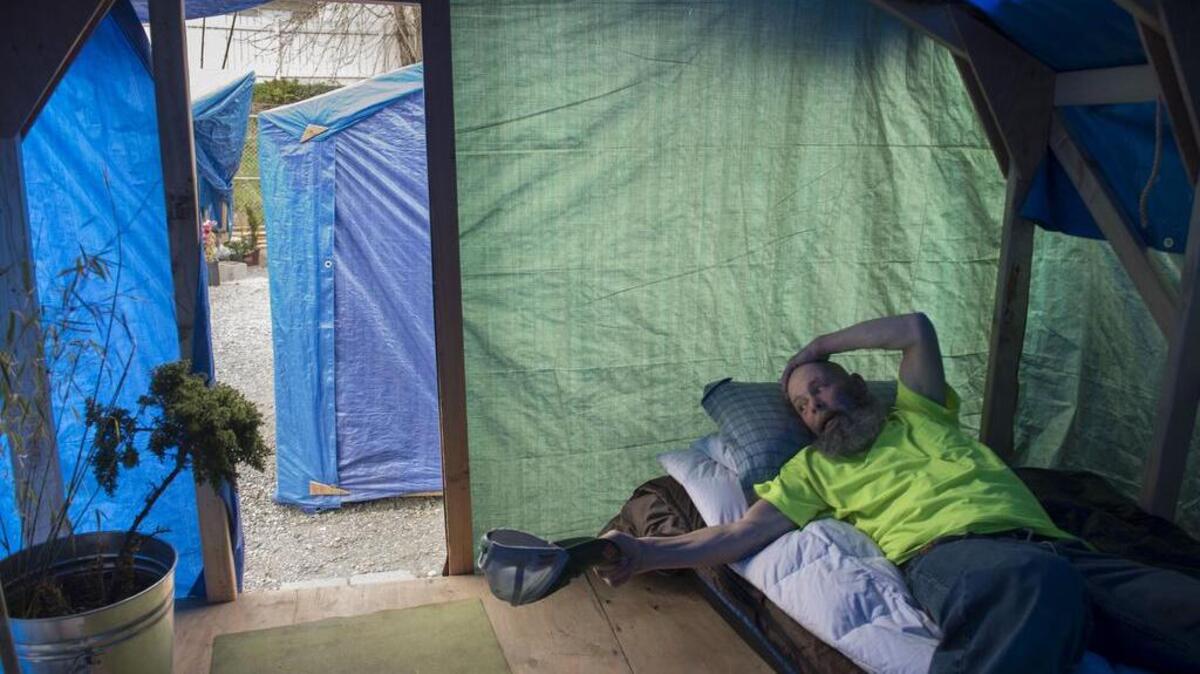 Gary Oaks rests on his bed in his tarp tent at the Nickelsville Tiny House Camp in the Ballard neighborhood of Seattle. Sacramento officials toured the city-sanctioned homeless camp last year while considering whether to open one here.