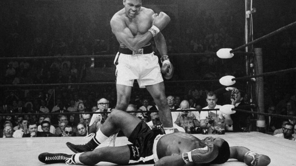 Heavyweight champion Muhammad Ali stands over fallen challenger Sonny Liston, shouting and gesturing shortly after dropping Liston on May 25, 1965.