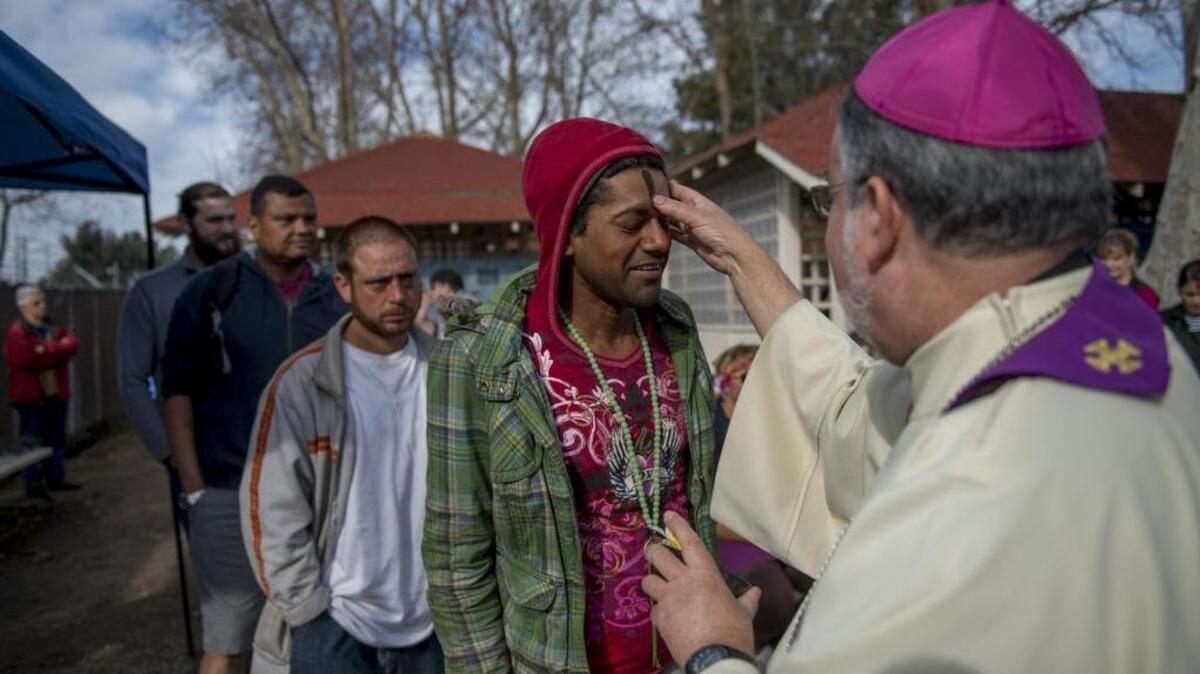 Amit Kumar, who has been homeless for one year, receives a blessing from Sacramento Catholic Bishop Jaime Soto on Ash Wednesday, Feb. 10, 2016.