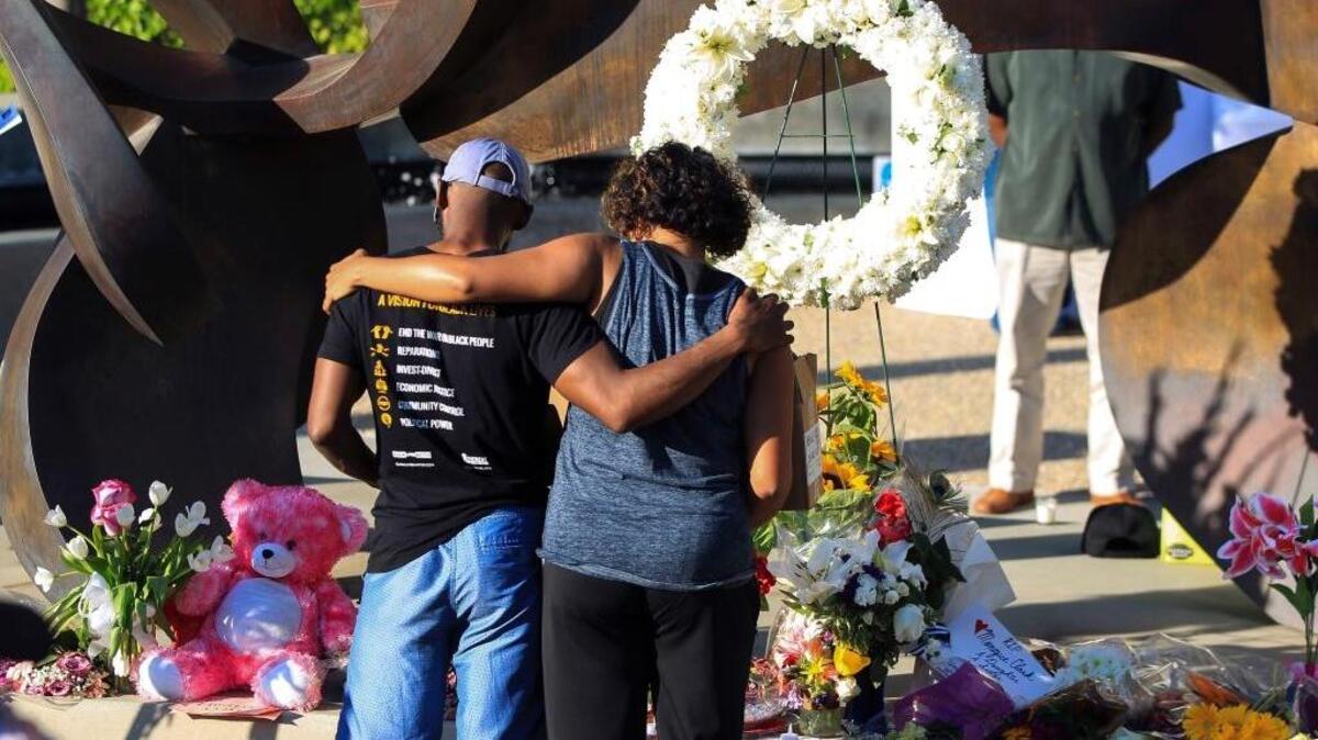 People mourn Wednesday before the start of a candlelight vigil and prayer service in San Diego for Monique Clark, who was killed when Peter Selis shot her and six other people attending a poolside birthday party on Sunday.