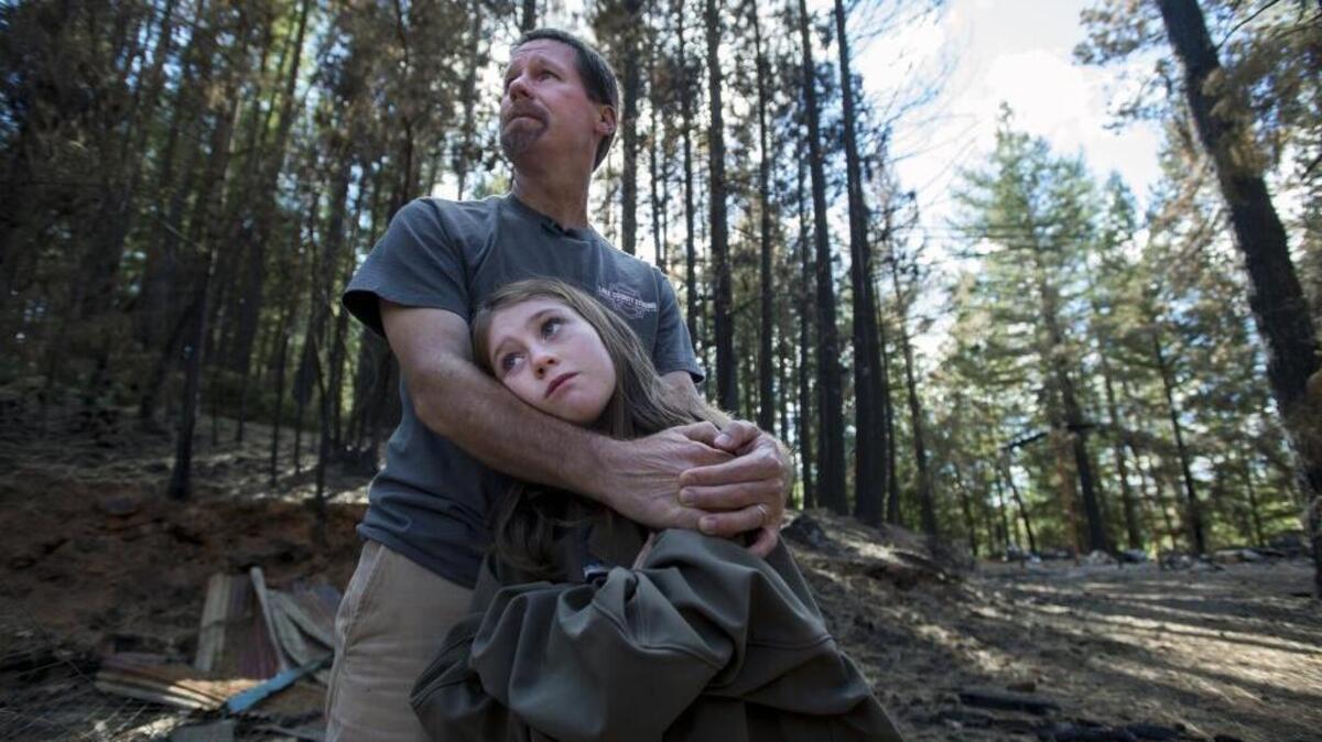 David Leonard and his daughter, Maya, survey the remains of their burned-out property on Cobb Mountain in the wake of last September’s Valley Fire in Lake County.