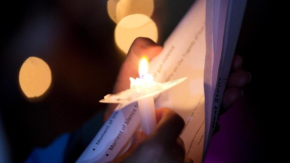 
Lit candles are held in remembrance of Alison Parker and Adam Ward during a vigil.
