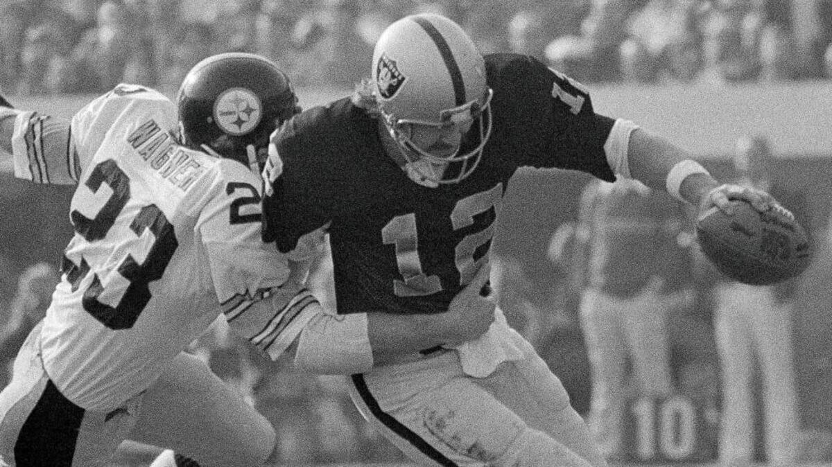 Oakland Raiders quarterback Ken Stabler is tackled by the Pittsburgh Steelers’ Mike Wagner for a 12-yard loss during the first period of the AFC championship NFL football game in Oakland on Dec. 26, 1976.