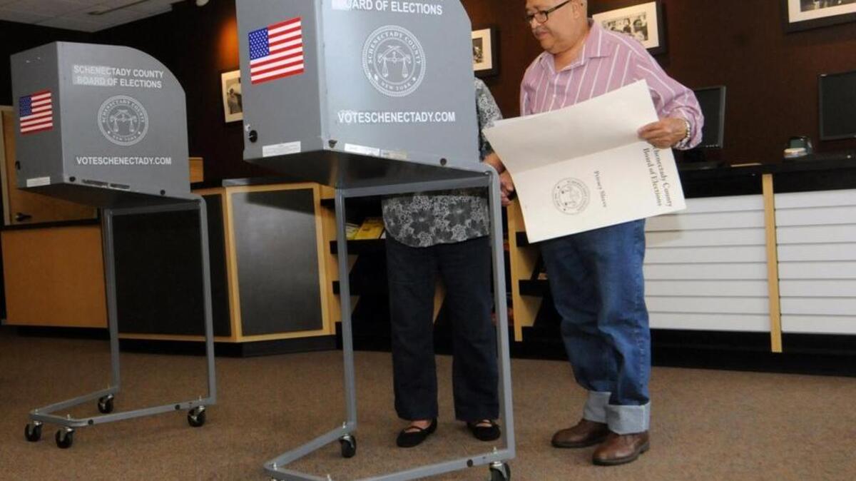 Marina and Arnulfo Ruiz decide on who to vote for at a polling place in Schenectady, N.Y.