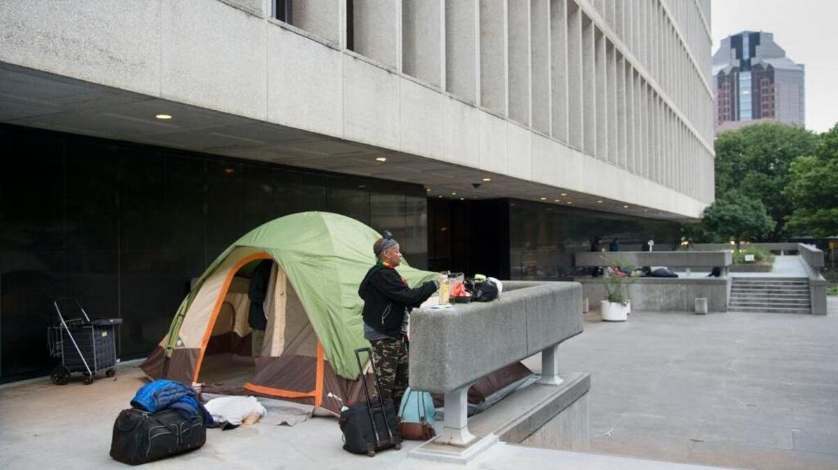 Latonia Randle, 48, packs up her belongings early in the morning after spending the night with her husband in their tent on the west side of the Sacramento County courthouse in April. Homeless people have been camping overnight for months at the courthouse, enticed by its relative safety, security and proximity to services. But court leaders and law enforcement, frustrated by their numbers, security issues and costs of cleanup, are looking to state judicial officials for answers.