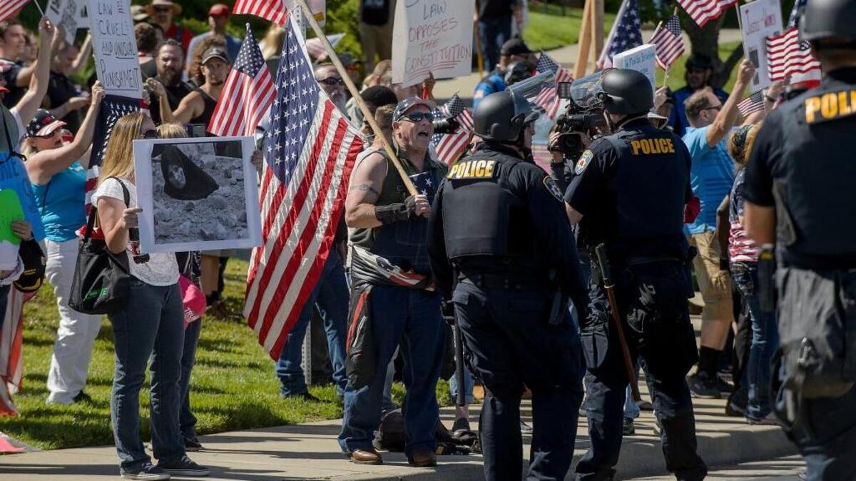 Roseville police officers talk with anti-sharia law demonstrators during a political rally near the Westfield Galleria in Roseville on Saturday.