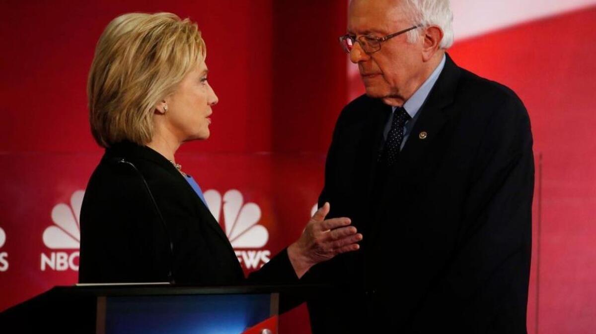 Hillary Clinton and Bernie Sanders speak during a break at the NBC/YouTube Democratic presidential debate Sunday in Charleston, S.C.
