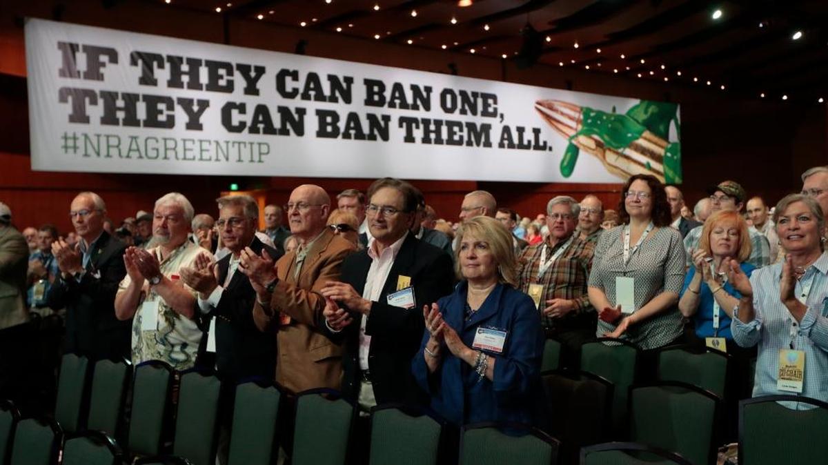 People applaud a speaker at the National Rifle Association convention last April in Nashville. Leonard Pitts Jr. asks since the GOP has marched in lockstep with the NRA, why not guns inside its national convention?