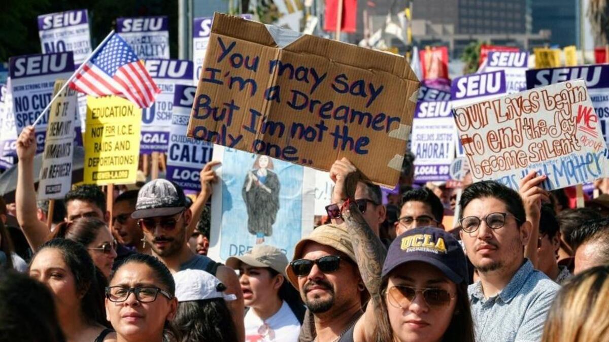 Supporters of the Deferred Action for Childhood Arrivals, or DACA chant slogans and hold signs while joining a Labor Day rally in downtown Los Angeles on Monday, Sept. 4, 2017. (AP Photo/Richard Vogel)
