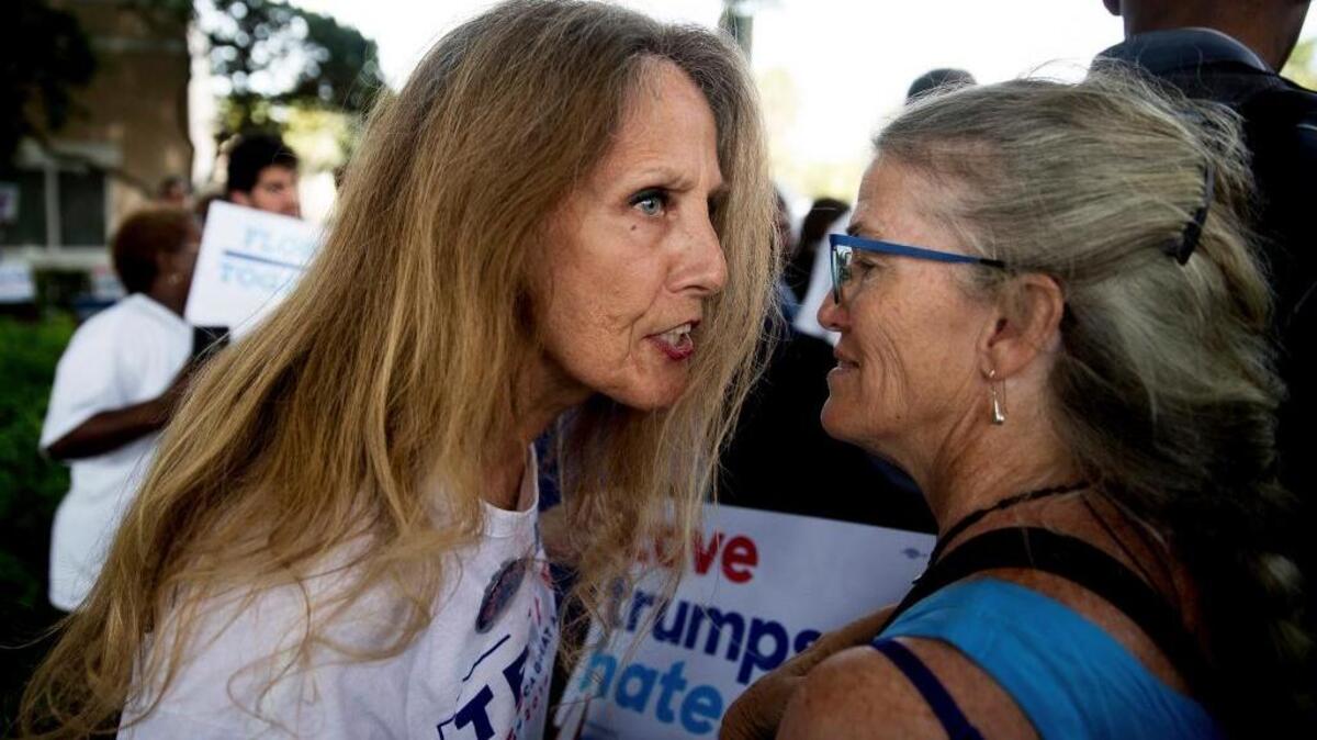 A Hillary Clinton supporter, right, is confronted by a Donald Trump supporter as Clinton visits an early voting station in Pompano Beach, Fla., on Sunday.