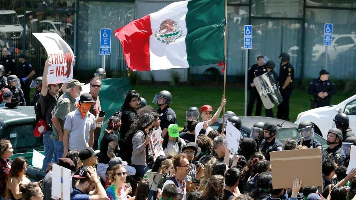 A protester against Donald Trump waves a Mexican flag outside the Hyatt Regency hotel last Friday in Burlingame, where the California Republican Party held its convention.