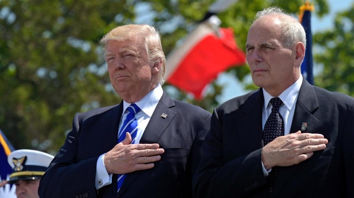 President Donald Trump and John Kelly listen to the national anthem during commencement exercises at the U.S. Coast Guard Academy in New London, Conn.