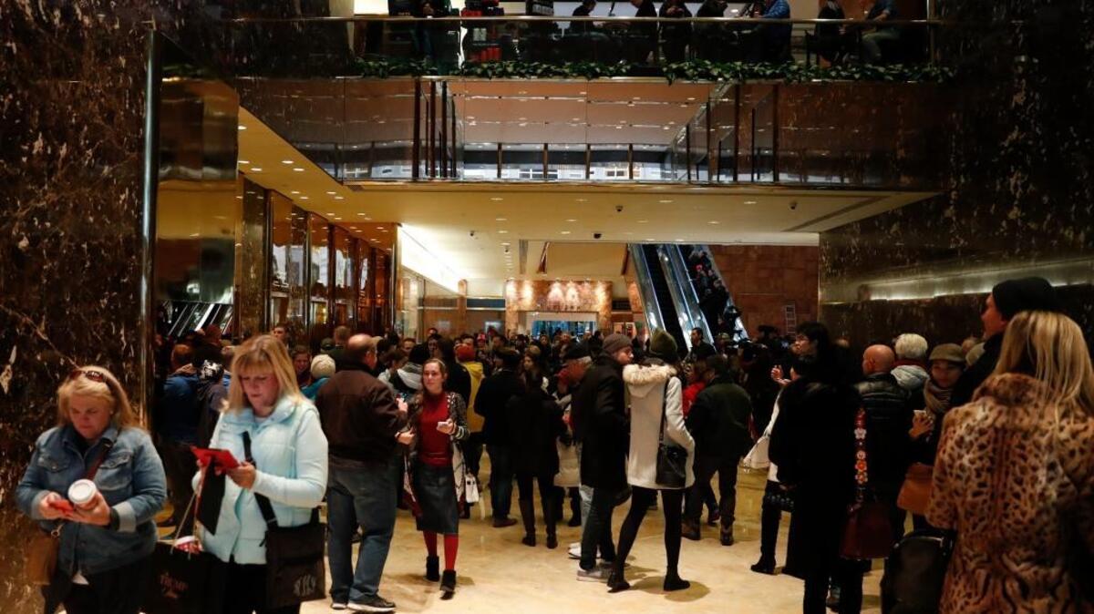 Tourists, pedestrians and security gather in the lobby of Trump Tower in New York on Monday. Upstairs, the president-elect is planning his administration and meeting with business partners.