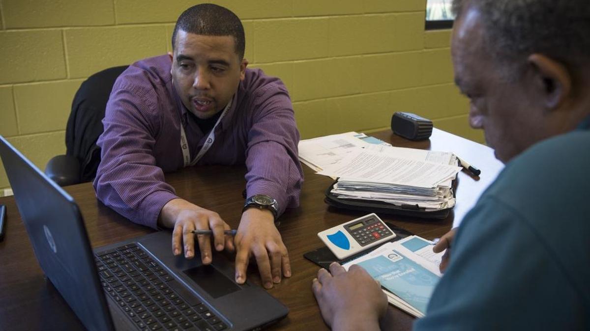Jamel Johnson, left, goes over Covered California insurance plans with Mark Burch in January.