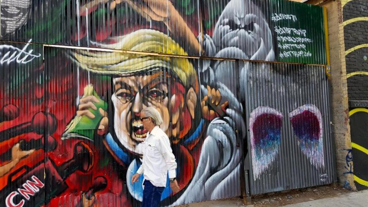 A pedestrian walks past a street mural of Donald Trump in downtown in Los Angeles on Wednesday.