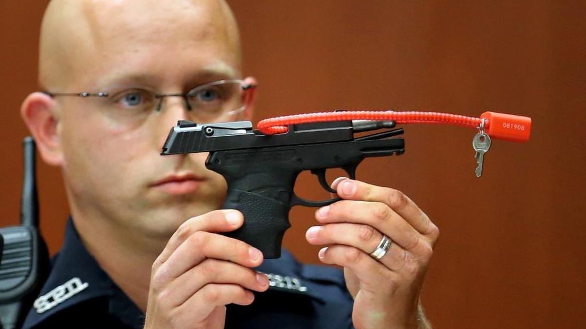 In this 2013 file photo, a Sanford police officer holds up the gun that was used to kill Trayvon Martin, while testifying in the George Zimmerman trial in Sanford. The pistol Zimmerman used in the fatal shooting of Martin is going up for auction online.
