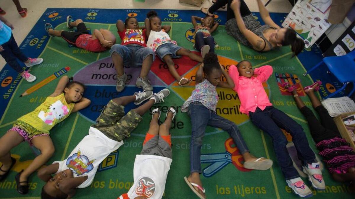 
Children in the College Bound Babies program do sit-ups in July 2014 at the Roberts Family Development Center in Sacramento. A new study says that fewer people are obese in neighborhoods that provide more fresh food and safe places to exercise. 
