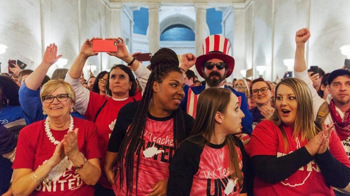 West Virginia teachers react at the state Capitol on Tuesday to news that Gov. Jim Justice and Senate Republicans reached a tentative deal to end a strike by giving them 5 percent raises.