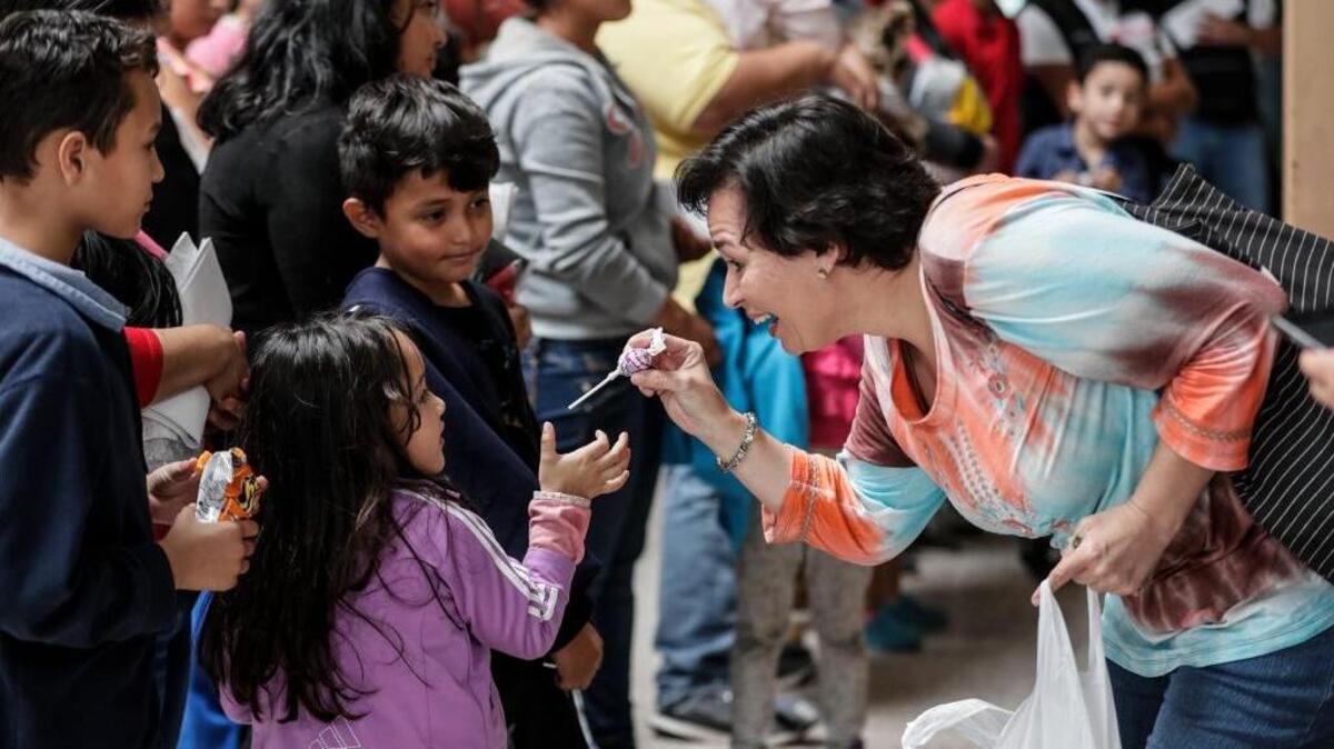 Karen Wulschner gives candy to immigrant children as they are processed at Central Station in McAllen, Texas, on Thursday, July 26, 2018. Waves of families passed through the station after they were released from federal custody. (Robert Gauthier/Los Angeles Times/TNS)