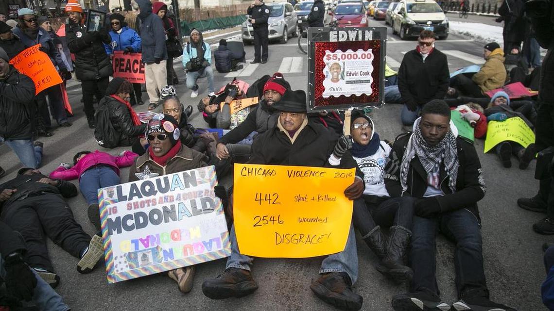 Community activists, including the Rev. Jesse Jackson, center, block Michigan and Chicago avenues to protest against gun violence on New Year’s Eve in Chicago. Activists are keeping up the pressure on Mayor Rahm Emanuel over shootings by police and gun violence in the city.