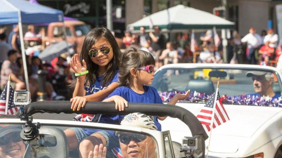 Phoebe Villasol and her sister Jasmine Villasol wave to people along the parade route during the Modesto Fourth of July Celebration. According to a new concept, Modesto is now part of the Bay Area Megaregion.