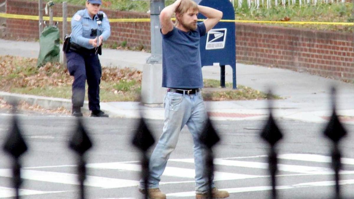 Edgar Maddison Welch, 28 of Salisbury, N.C., surrenders to police on Sunday in Washington. Welch, who said he was investigating a conspiracy theory about Hillary Clinton running a child sex ring out of a pizza restaurant, fired an assault rifle inside.