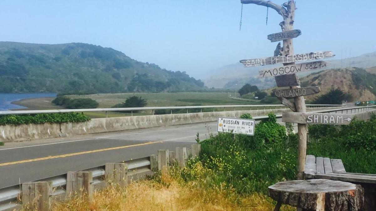 A sign post with Russian cities marks a bridge crossing the Russian River at Jenner.