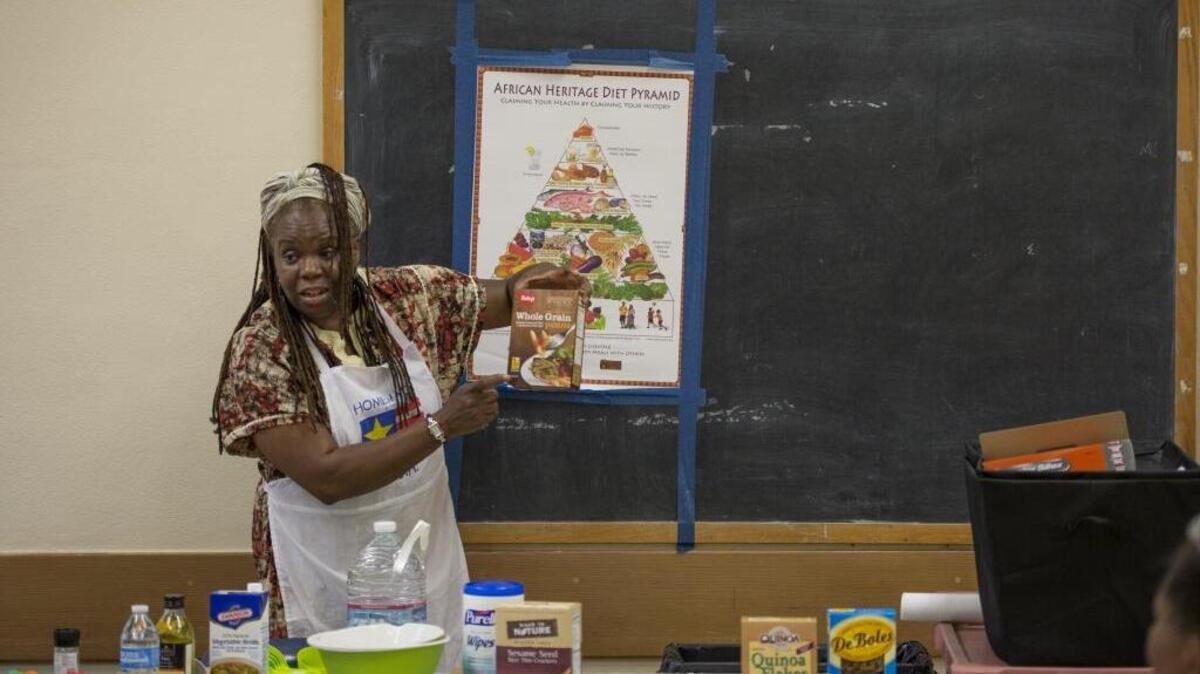 Toni Colley-Perry shows off a box of whole grain pasta as she teaches a free cooking class in Oak Park last month to promote healthy eating.