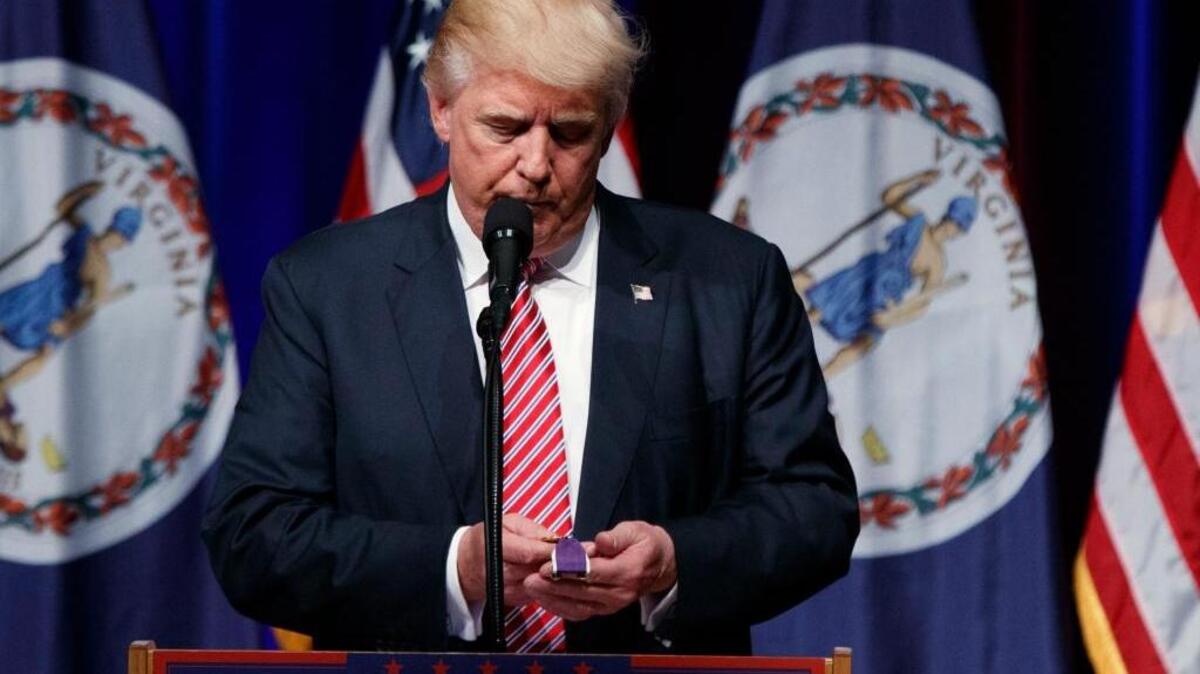 Donald Trump holds a Purple Heart medal given to him by a supporter during a campaign rally at Briar Woods High School, in Ashburn, Va., in August.