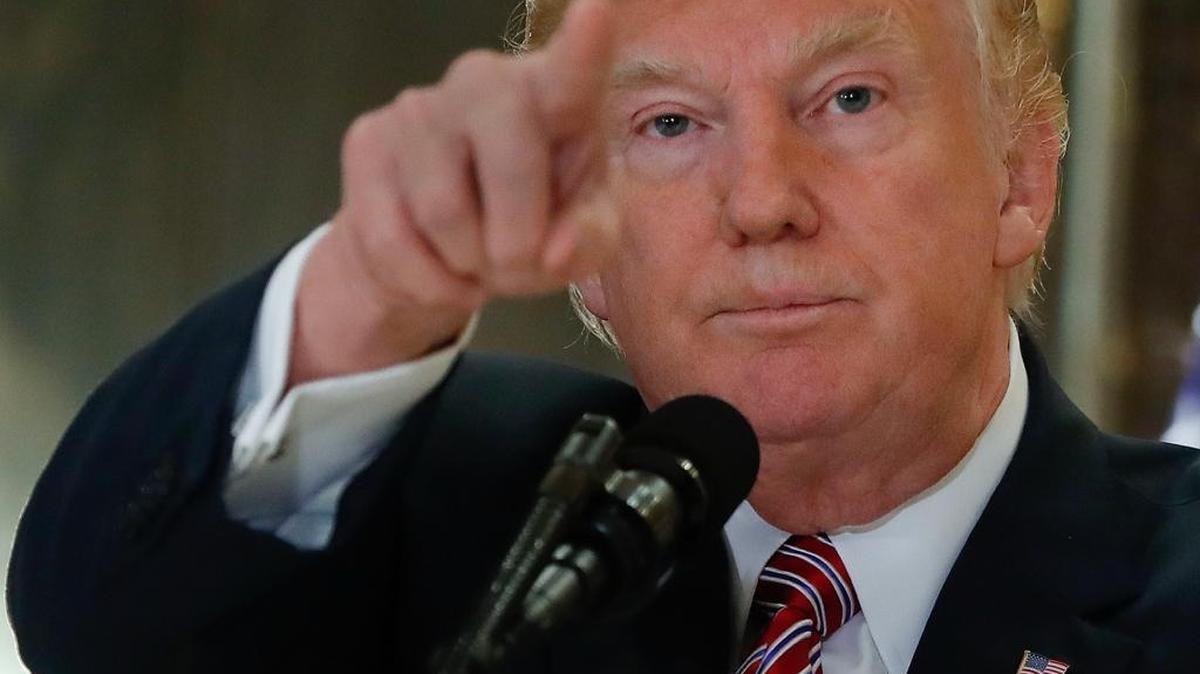President Donald Trump points to a member of the media while speaking in the lobby of Trump Tower on Tuesday about the violence at a white supremacist rally in Charlottesville, Va.