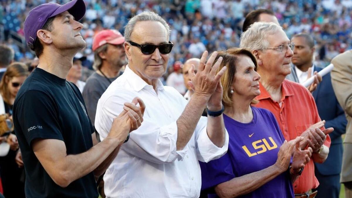 From left, House Speaker Paul Ryan, Senate Democratic leader Chuck Schumer, House Democratic leader Nancy Pelosi and Senate Majority Leader Mitch McConnell applaud a message by President Donald Trump on the video board before the annual congressional baseball game on Thursday.