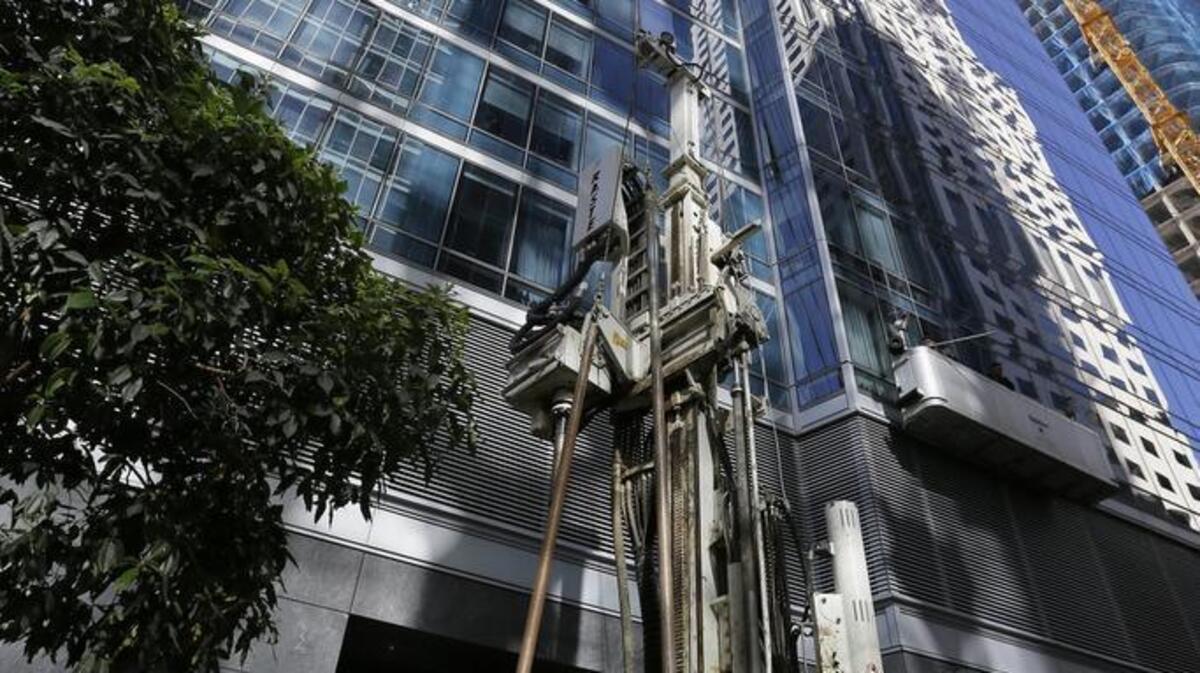 Soil engineers work outside the Millennium Tower in San Francisco in September 2016. The 58-story building has gained notoriety as the “leaning tower of San Francisco.” But Joe Mathews says California’s fear of high rises is making the housing shortage worse.
