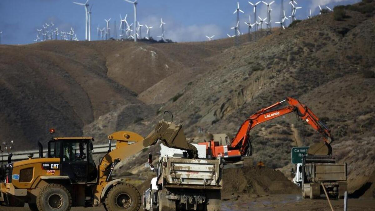 Workers remove mud and debris on Highway 58 east of Tehachapi in October. The mountain range both divides and connects California, Joe Mathew writes.