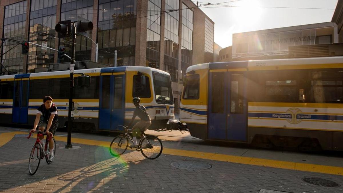 Bicyclists wait for the light-rail train to pass at Seventh and K streets in 2013. Daniel Weintraub says the only direct route between downtown Sacramento and Township Nine is dangerous for cyclists.