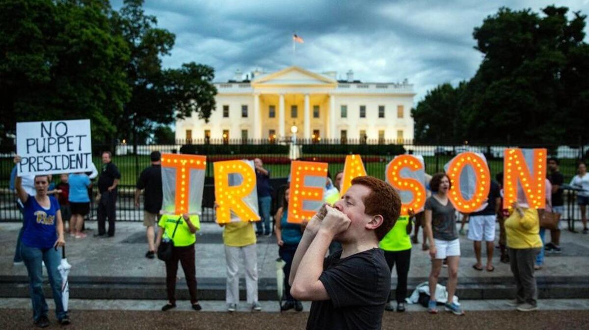 Protestors hold signs and chant slogans outside the White House after President Donald Trump’s return from his golf club in Bedminster, N.J., on Sunday evening, July 22, 2018. (Al Drago/The New York Times)