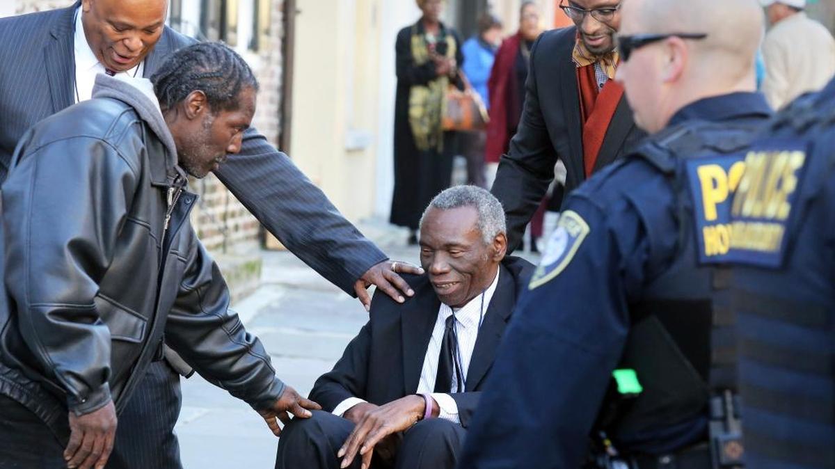 John Pinckney, father of shooting victim the Rev. Clementa Pinckney, is greeted Dec. 15 after leaving the federal courthouse in Charleston, S.C., where Dylann Roof was found guilty of all 33 federal charges in the Emanuel AME Church shootings.