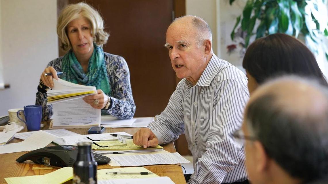 Gov. Jerry Brown discusses a bill with advisor Nancy McFadden, left, at his Capitol office in Sacramento in September 2014. McFadden, the chief of staff to Brown, died Thursday.