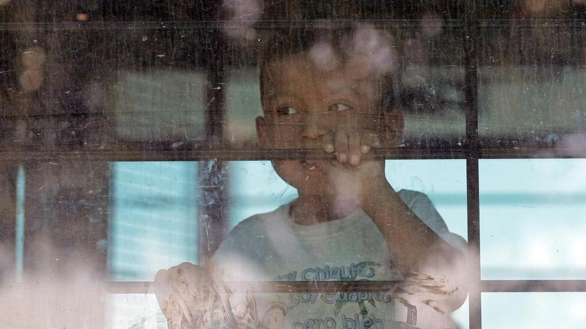 A migrant child looks out from a U.S. Border Patrol bus leaving as protesters block the street outside the Border Patrol processing center in McAllen, Texas, on June 23, 2018..