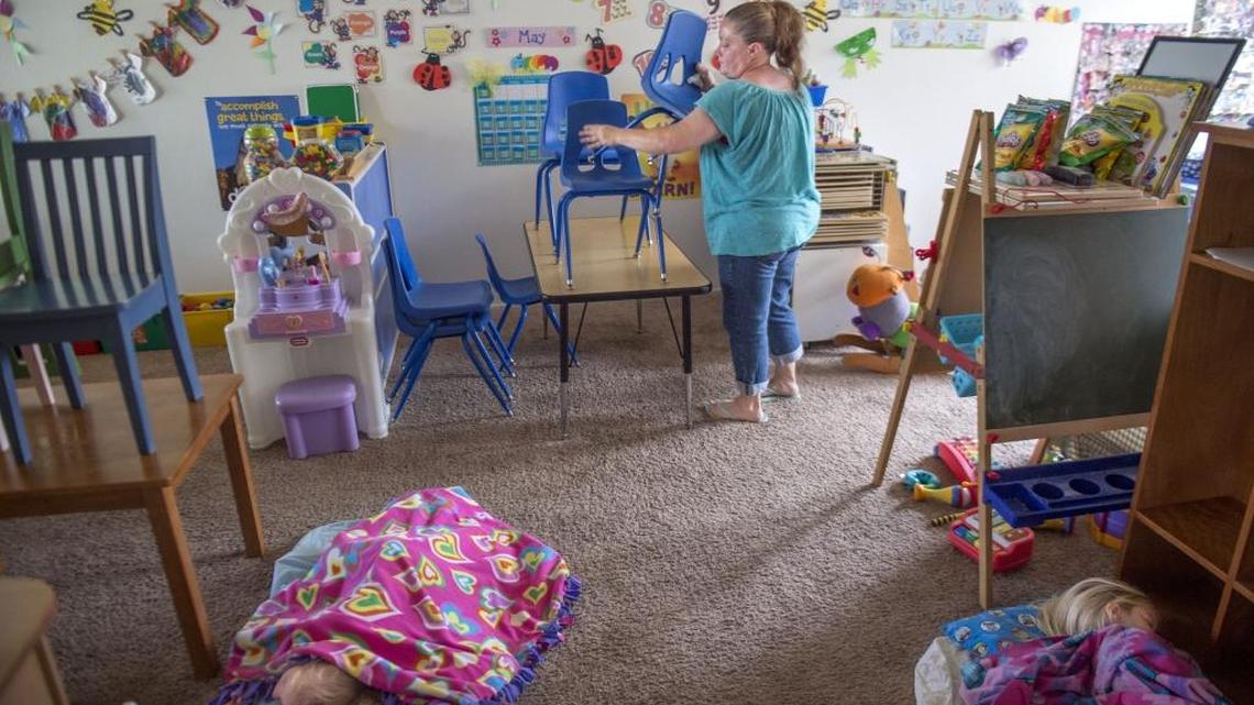 Tisa Kelley, a Sacramento child-care provider, puts away chairs after lunch.