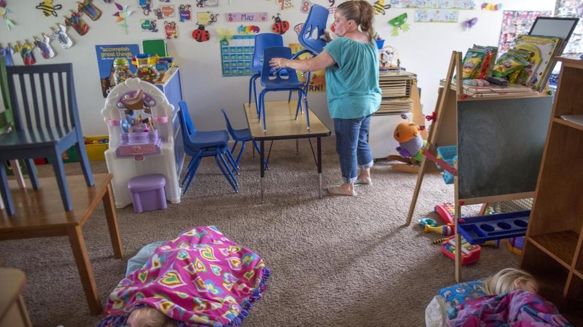Tisa Kelley, cuidadora de niños de Sacramento, guarda las sillas después del almuerzo.